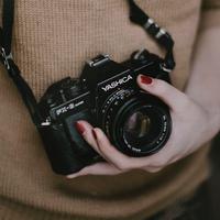 A female hand holding a camera